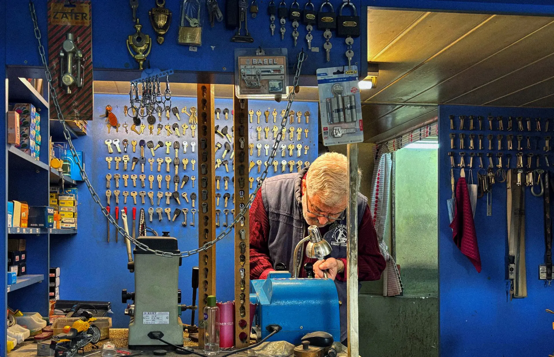 Artisan au travail sur une machine de reproduction de clés dans l’atelier